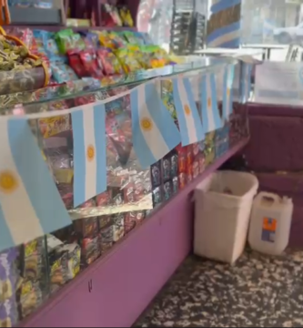 img data-src="image.png" alt="Fachada del local comercial La Goleta luciendo grandes banderas argentinas en sus ventanas y accesos principales."